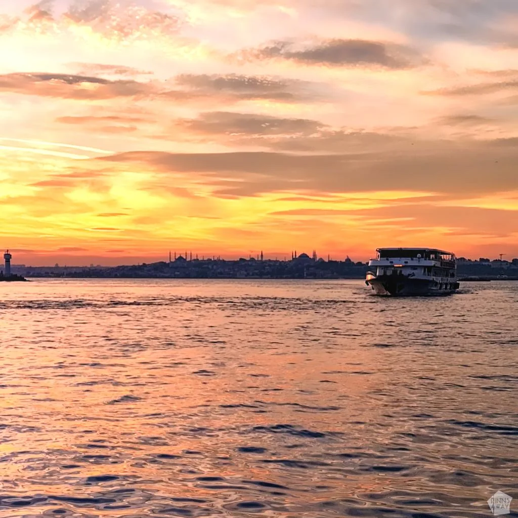 Auringonlaskun maisema Kadiköyssa, kaupungin silhuetti ja laiva | Istanbul, Turkki | InTravel blogi